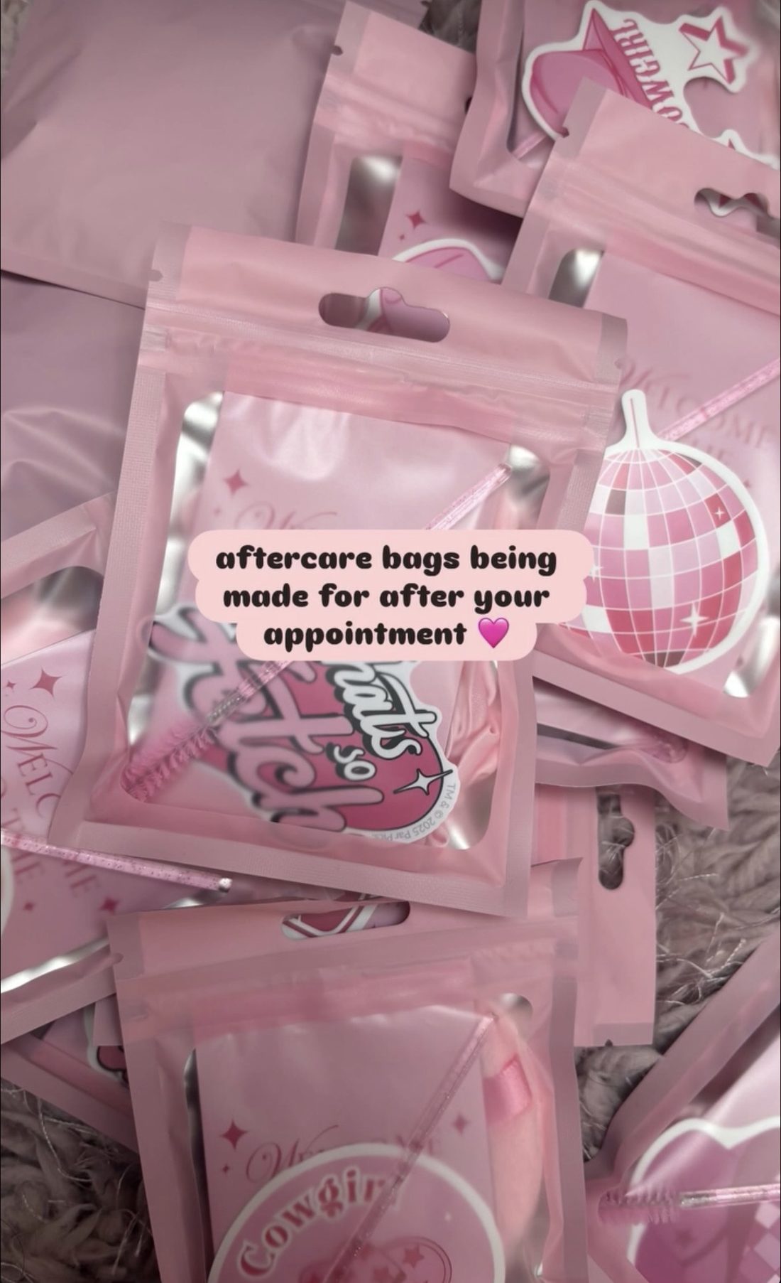 Pink aftercare bags with stickers, made up ready for clients after their appointment