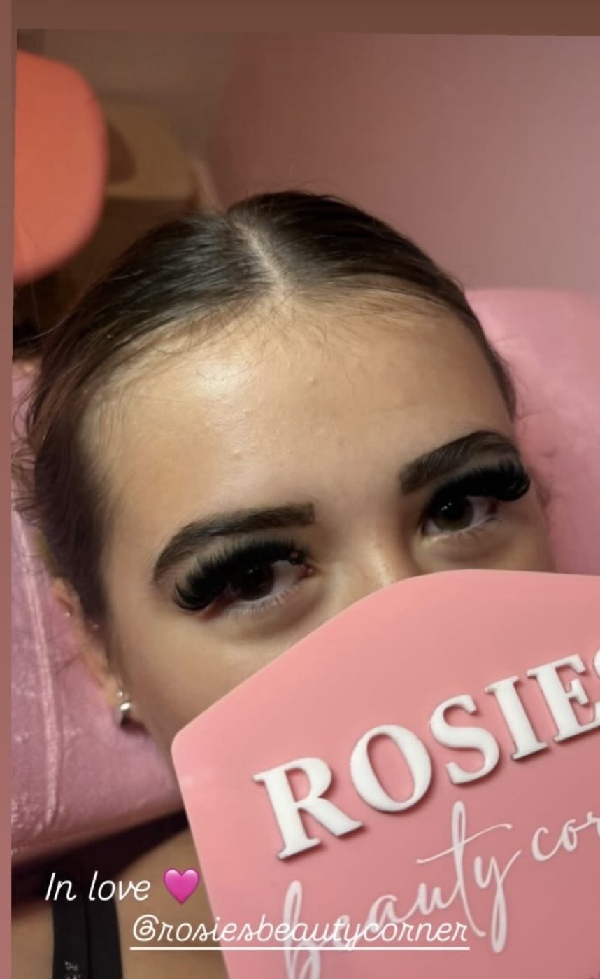 Russian volume lash set, client holding the Rosie's Beauty Corner mirror